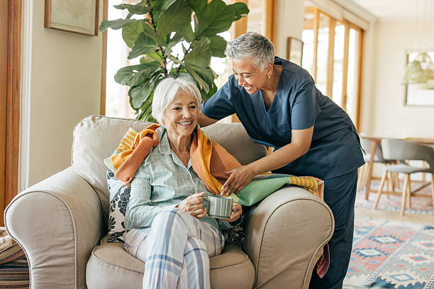A caregiver gently wrapping a warm blanket around a happy resident